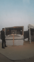 Man observed standing in makeshift refugee camp