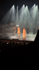 Ballet performance unfolds on a dimly lit theatrical stage