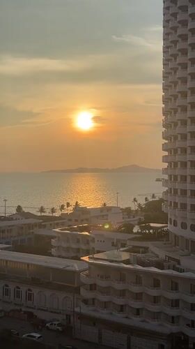 Sunset cityscape captured over water in Pattaya, Thailand