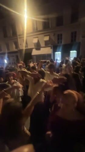 Night street dancing in Paris, hands in the air