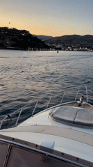 Yacht sailing toward Bodrum's coastline at dusk