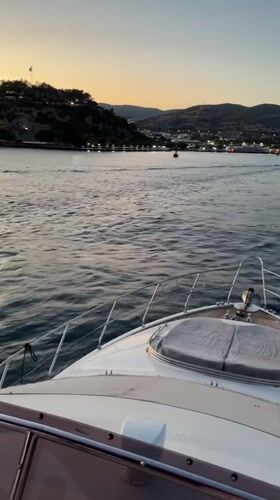 Yacht sailing toward Bodrum's coastline at dusk