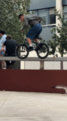 BMX rider performs tricks in Barcelona plaza amid city activity