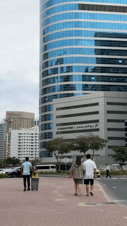 Man takes phone call on Dubai street near office building