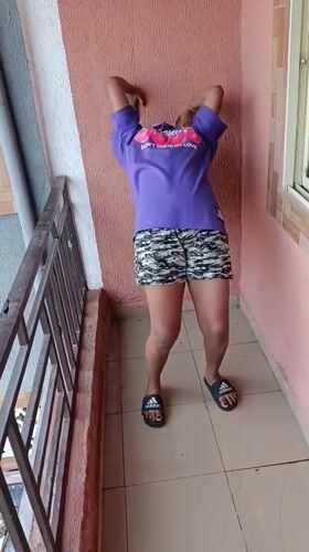 Woman does morning stretches on balcony in Obinagu, Nigeria