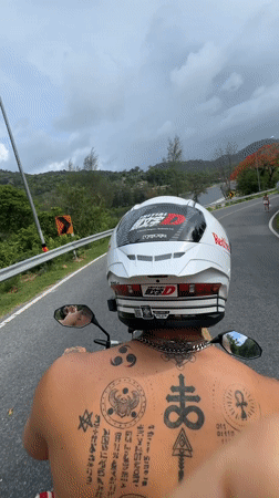 Couple rides motorcycle through Rawai Thailand early morning