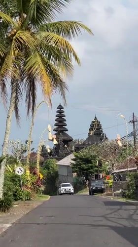 Balinese village road lined with traditional meru temple and ceremonial decor