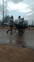 Street vendors conduct daily business during rainy afternoon