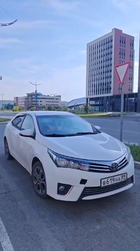 Two white Toyotas on Novy Urengoy streets, one minute apart