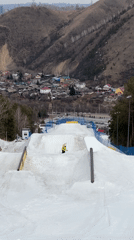 Snowboarders perform tricks and descend slopes at terrain park