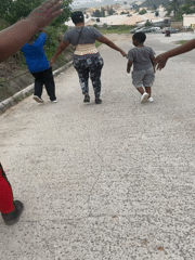 Morning foot and motorcycle traffic on an Abuja hillside road