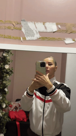 Person takes mirror selfie while removing wall object in Abakan