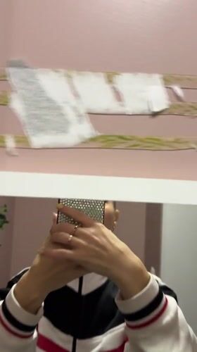 Person takes mirror selfie while removing wall object in Abakan