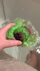 Green bath bomb dissolves into a candlelit tub in Hrodna