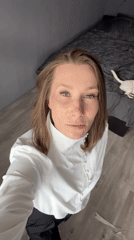 Woman in white shirt observed in Taldom interior setting