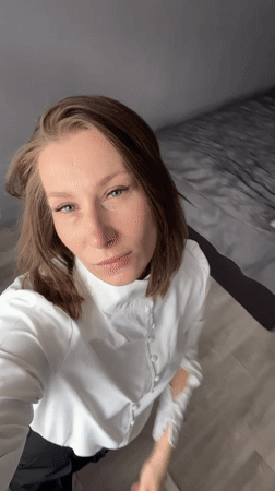 Woman in white shirt observed in Taldom interior setting