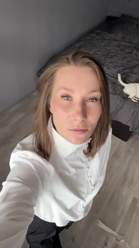 Woman in white shirt observed in Taldom interior setting