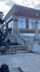 Scooter crew hits stair spot outside London, Canada brick building