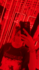 Woman films selfie in red-lit mirrored room in North Kuta