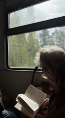 Elderly passengers read books during morning transit commute