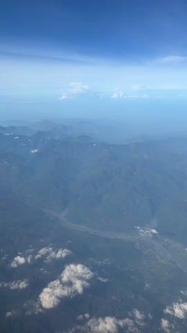 The video shows an aerial view of a mountainous landscape with a river winding through it. The sky is blue with some white clouds. The image is taken from an airplane, as indicated by the audio narration. The narration thanks the viewer for flying with Asia Philippines and hopes to see them again. The video is static and does not show any movement or action.