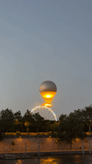 Hot air balloon and Ferris wheel light up Paris at dusk