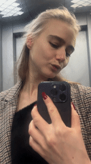 Woman takes elevator selfie with smartphone