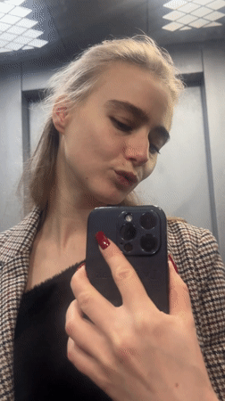 Woman takes elevator selfie with smartphone