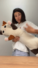 Woman plays with stuffed cat toy in Budva apartment