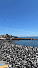 Clear day captured on Catania's dark stone beach