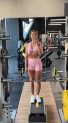 Woman takes mirror selfies in pink workout gear at Saint Petersburg gym