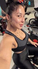 Woman records fitness video during spin class in Spain