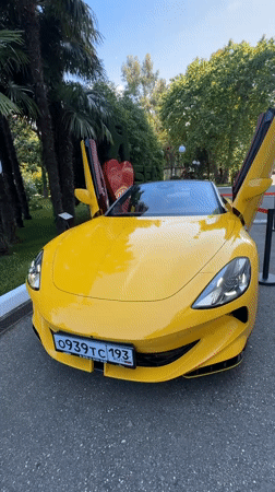 Yellow Ferrari with open doors parked in Sochi