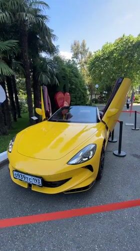 Yellow Ferrari with open doors parked in Sochi