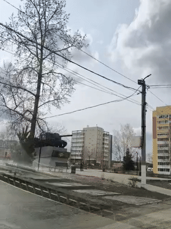 Vehicle passes tank monument in Chaikovsky public square