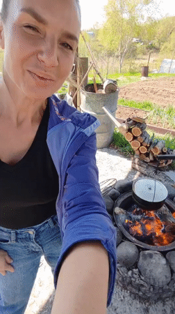 Woman documents early morning outdoor cooking, gardening in rural Russia