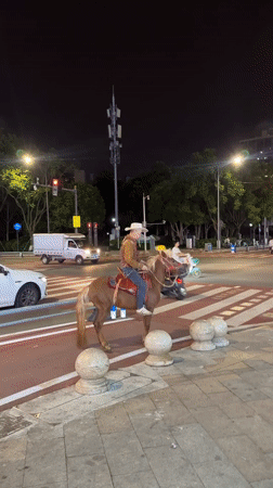 Cowboy rides horse through busy Chongqing streets at night