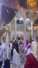 Wedding procession held in ornate hall in Marrakesh