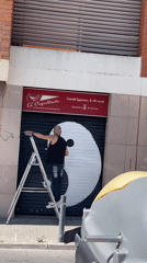 Artist paints yin yang symbol on storefront in Terrassa