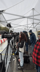 Media crews gather under tent near Geneva hotel
