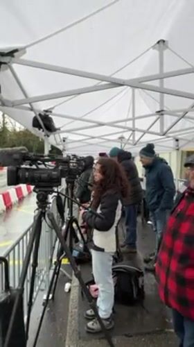 Media crews gather under tent near Geneva hotel