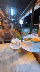 Woman enjoys evening meal at Thai street restaurant in Patong