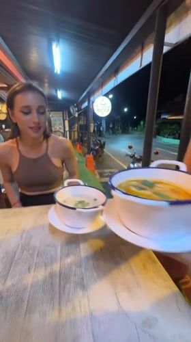 Woman enjoys evening meal at Thai street restaurant in Patong