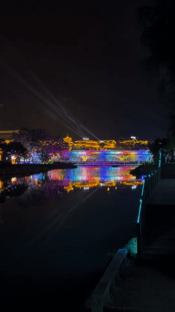 Colorful night lights illuminate traditional bridge in Wulingyuan waterway