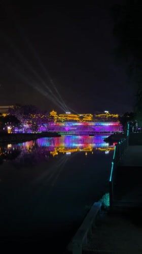 Colorful night lights illuminate traditional bridge in Wulingyuan waterway