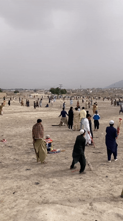 Children play in dusty Quetta neighborhood, one flying kite