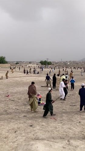 Children play in dusty Quetta neighborhood, one flying kite