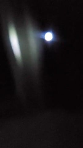 A light source illuminates a dark room, casting a bright spot and a hazy vertical beam.