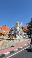 Morning traffic flows through tree-lined streets in Bali