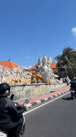 Morning traffic flows through tree-lined streets in Bali